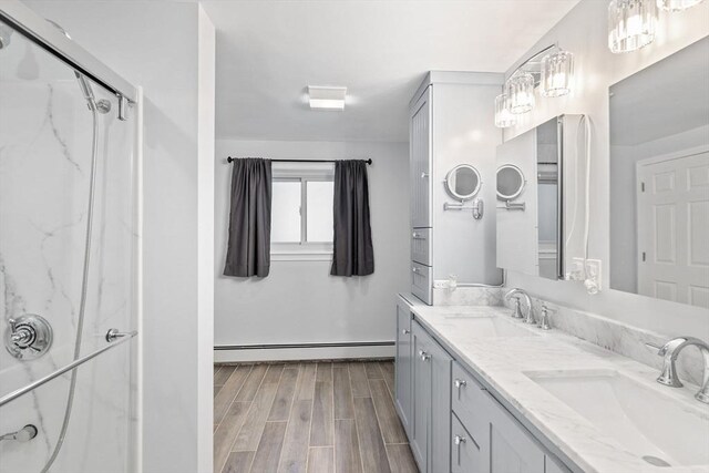 11 Michael Rd, Bourne, MA 02559 - bathroom with wood finished floors, a marble finish shower, a sink, and a baseboard radiator