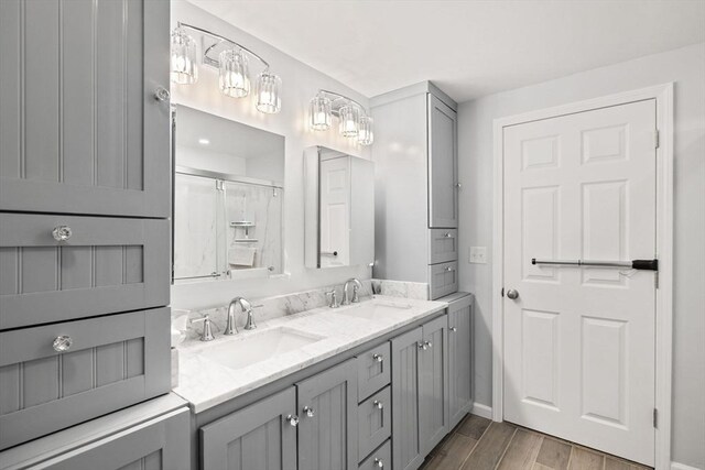 11 Michael Rd, Bourne, MA 02559 - bathroom with double vanity, wood finished floors, baseboards, and a sink
