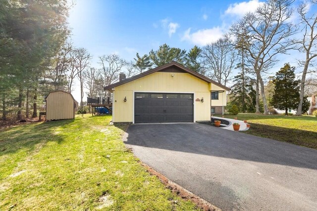 11 Michael Rd, Bourne, MA 02559 - view of side of home with a storage unit, a chimney, a garage, a lawn, and an outdoor structure