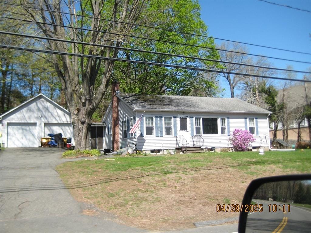 ranch-style house featuring a chimney, a front yard, a detached garage, an outdoor structure, and entry steps