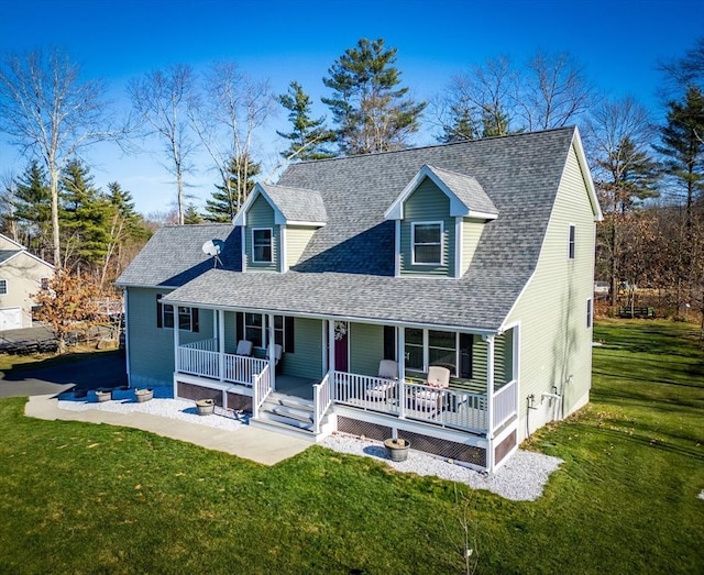 cape cod-style house featuring covered porch, a shingled roof, and a front yard