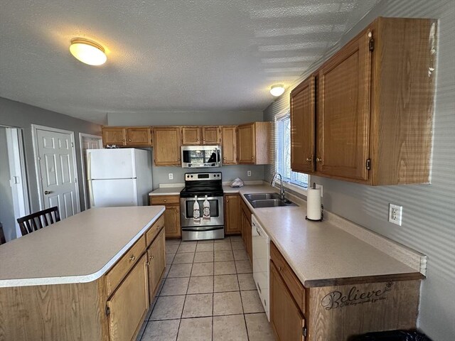 kitchen featuring a sink, a textured ceiling, appliances with stainless steel finishes, and light countertops