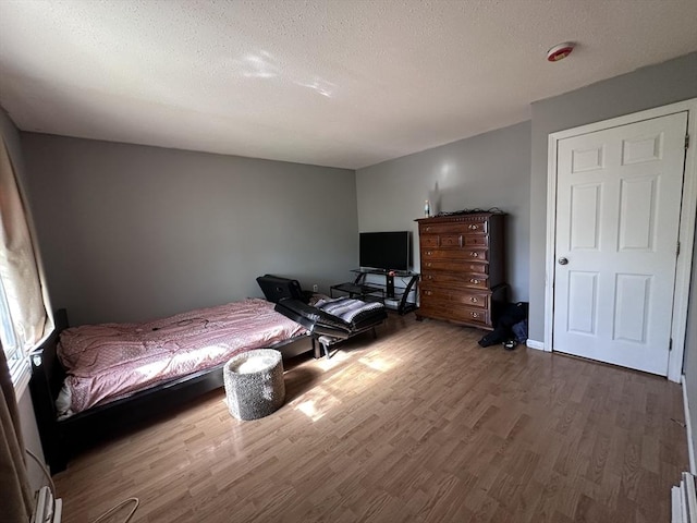 bedroom featuring a textured ceiling and wood finished floors