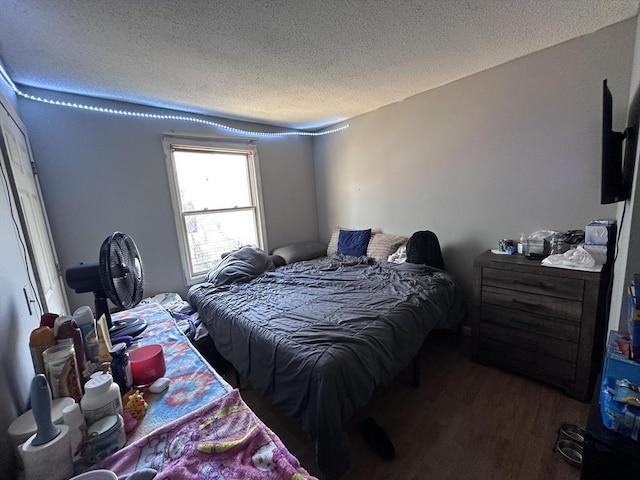 bedroom with a textured ceiling and wood finished floors