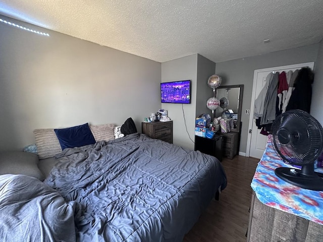 bedroom featuring a textured ceiling and wood finished floors