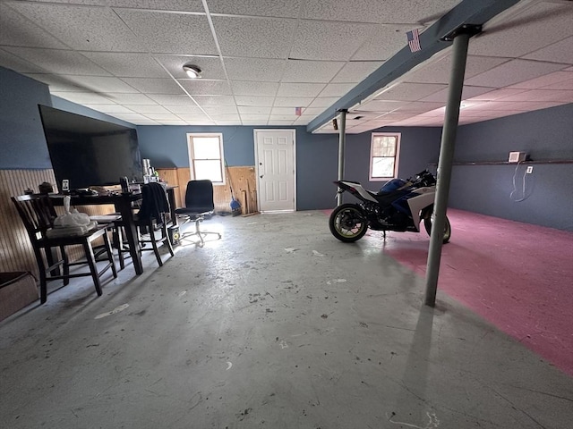 below grade area featuring a drop ceiling and a wainscoted wall