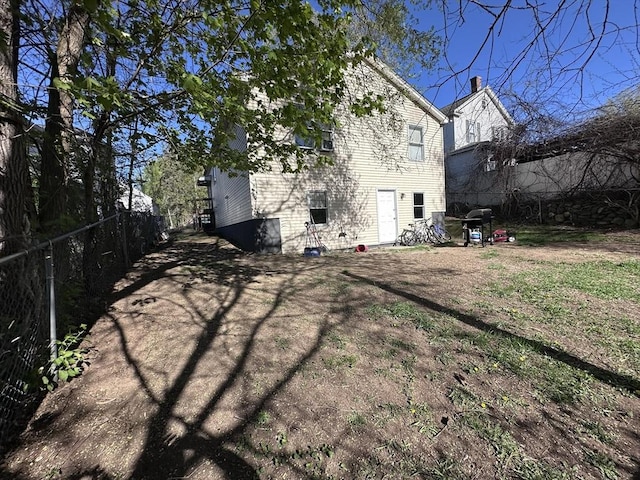 rear view of house featuring fence