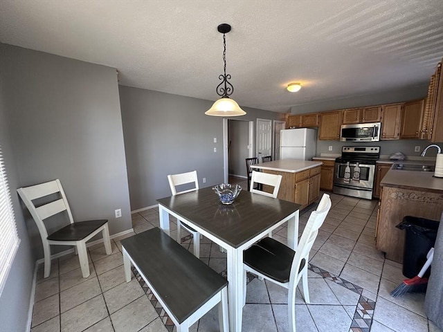 dining room featuring baseboards, a textured ceiling, and light tile patterned flooring