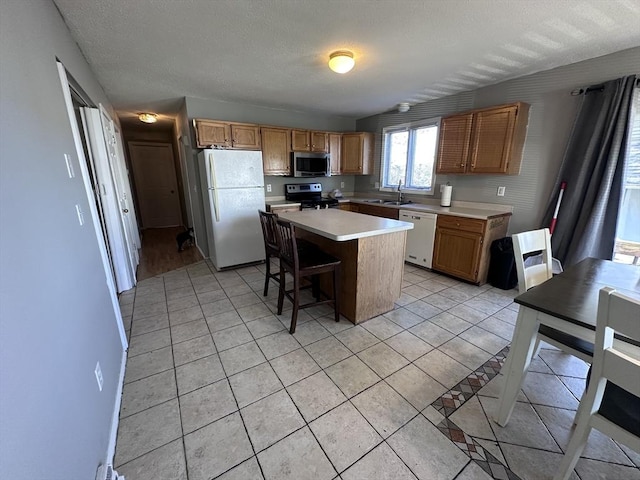 kitchen featuring light countertops, stainless steel appliances, light tile patterned floors, and a sink
