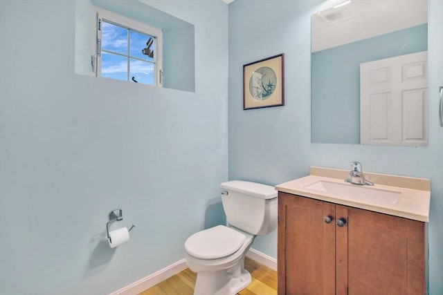 bathroom with vanity, toilet, and wood-type flooring