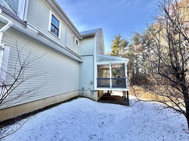 view of snow covered exterior with a sunroom