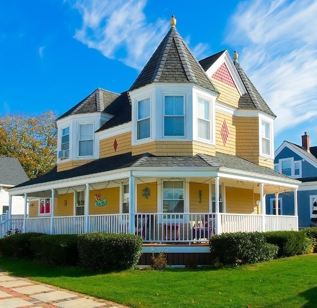 victorian house with a front yard and covered porch