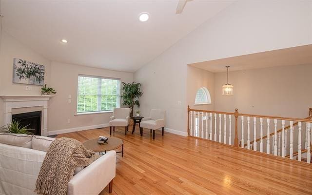 41 Winchester Unit 0, Hampstead, NH 03826 - living area featuring light wood-style floors, baseboards, a glass covered fireplace, high vaulted ceiling, and recessed lighting