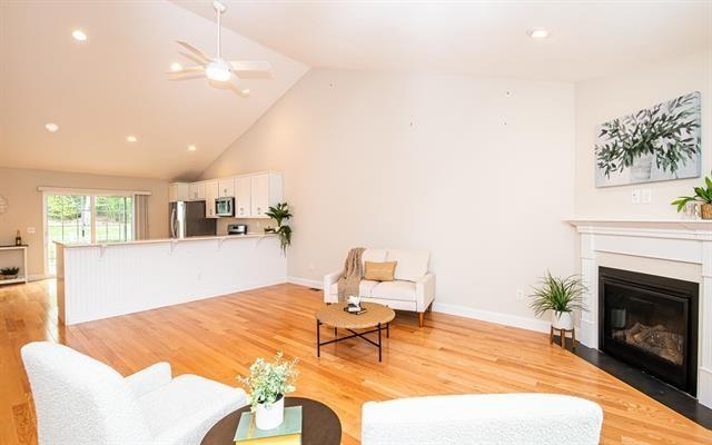 41 Winchester Unit 0, Hampstead, NH 03826 - living area featuring a ceiling fan, a glass covered fireplace, light wood-type flooring, high vaulted ceiling, and baseboards