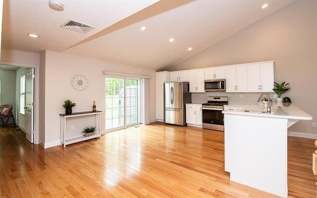 41 Winchester Unit 0, Hampstead, NH 03826 - kitchen with stainless steel appliances, a sink, light countertops, a peninsula, and light wood-type flooring