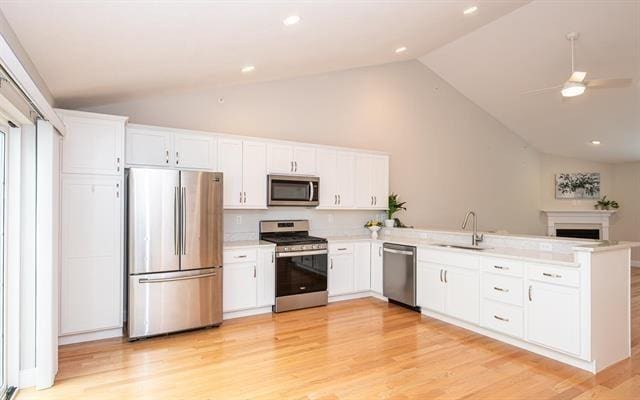41 Winchester Unit 0, Hampstead, NH 03826 - kitchen with appliances with stainless steel finishes, vaulted ceiling, a sink, a peninsula, and white cabinetry