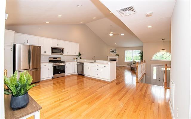 41 Winchester Unit 0, Hampstead, NH 03826 - kitchen featuring stainless steel appliances, lofted ceiling, a peninsula, light wood finished floors, and white cabinets