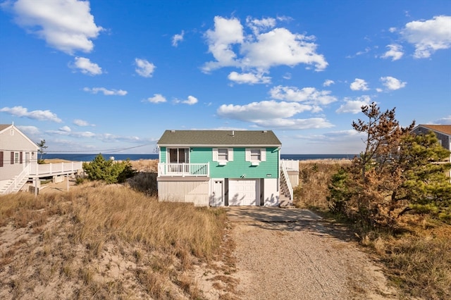 view of front of property featuring a garage and a water view