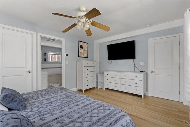bedroom featuring a ceiling fan, visible vents, baseboards, light wood finished floors, and ensuite bathroom