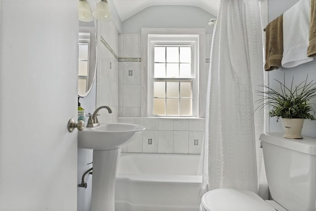 full bathroom featuring toilet, vaulted ceiling, and shower / bathtub combination with curtain