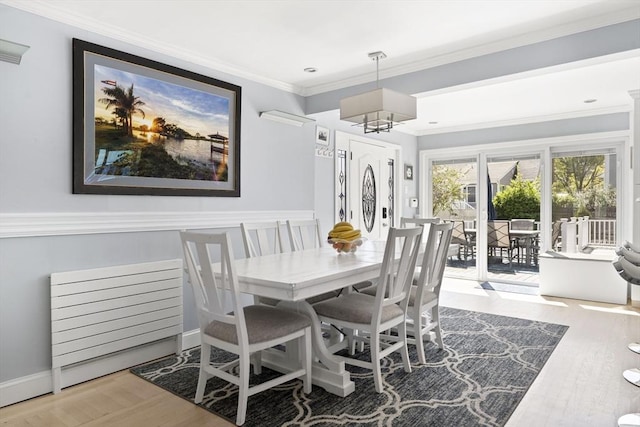 dining room featuring crown molding, wainscoting, and wood finished floors