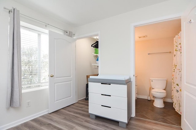 interior space with vanity, hardwood / wood-style flooring, and toilet