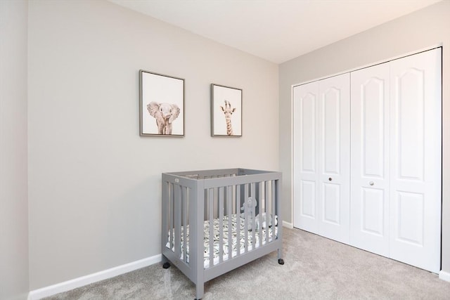 bedroom featuring light carpet, a crib, and a closet