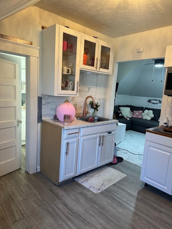 kitchen featuring lofted ceiling and white cabinets