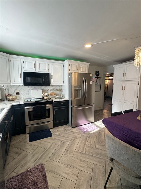 kitchen with light parquet flooring, white cabinetry, backsplash, and stainless steel appliances