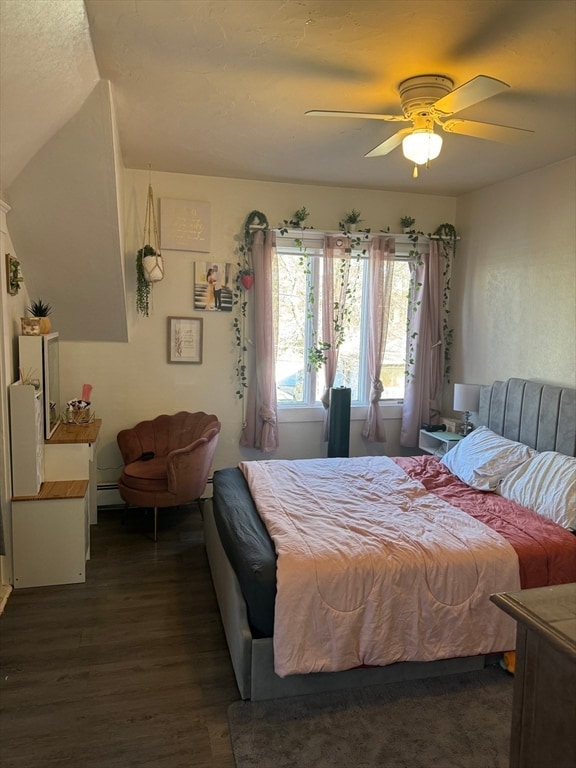 bedroom featuring baseboard heating, ceiling fan, and dark hardwood / wood-style floors