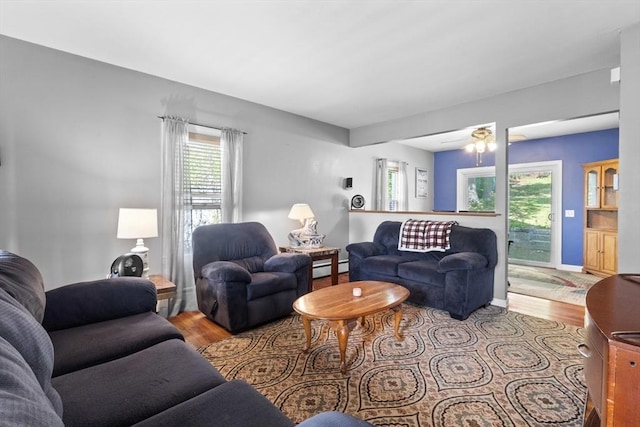 living room with a baseboard radiator, wood finished floors, and a ceiling fan
