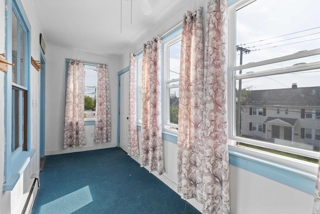 unfurnished sunroom featuring a baseboard heating unit