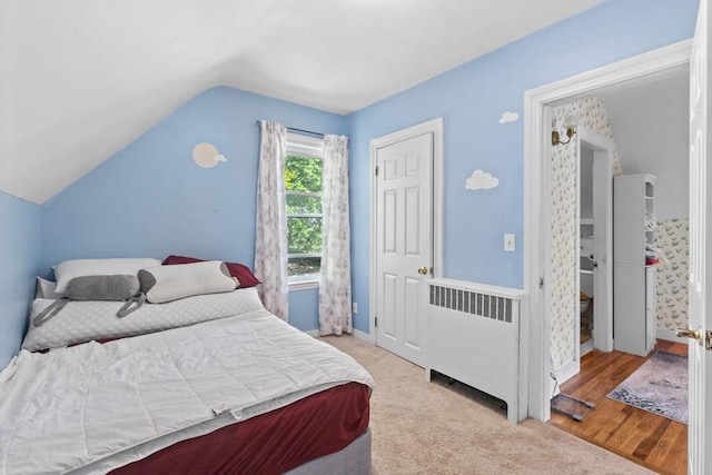 bedroom with radiator heating unit, lofted ceiling, and baseboards