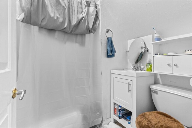 bathroom featuring a shower with curtain, vanity, and toilet