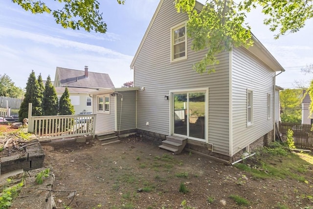 back of house featuring entry steps, fence, and a wooden deck