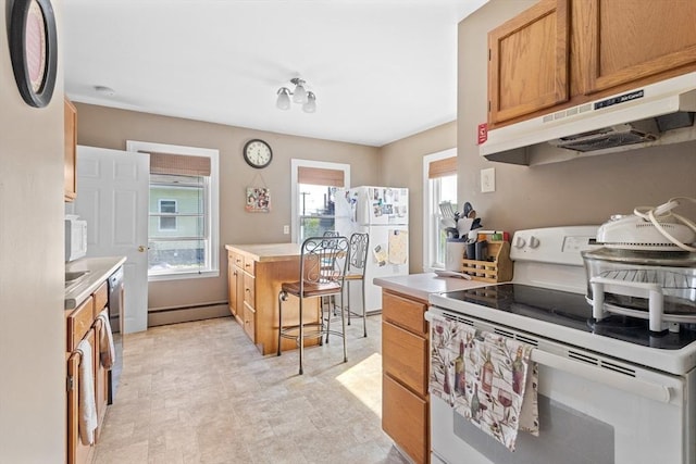 kitchen with white appliances, baseboard heating, under cabinet range hood, light countertops, and brown cabinets