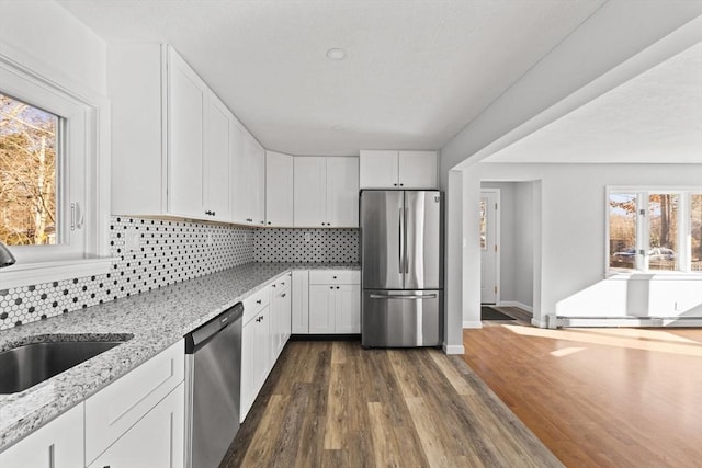 kitchen featuring dark wood-type flooring, sink, light stone countertops, white cabinetry, and stainless steel appliances