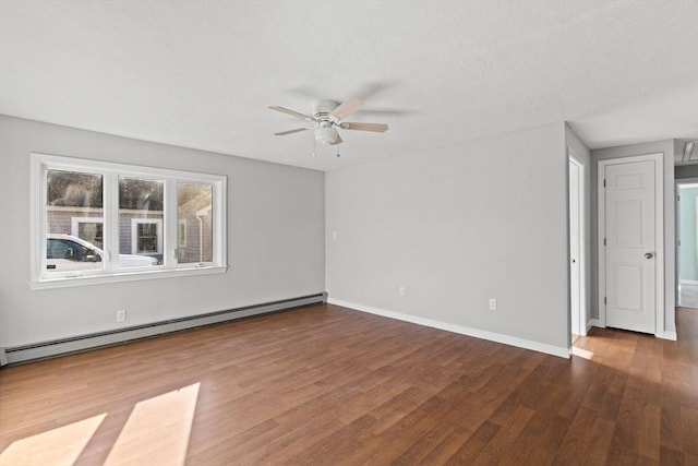 spare room with dark hardwood / wood-style flooring, ceiling fan, and a baseboard heating unit