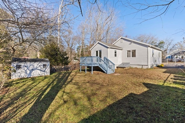 back of house with a yard, a deck, and a storage unit