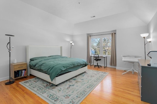 bedroom featuring hardwood / wood-style floors and a tray ceiling