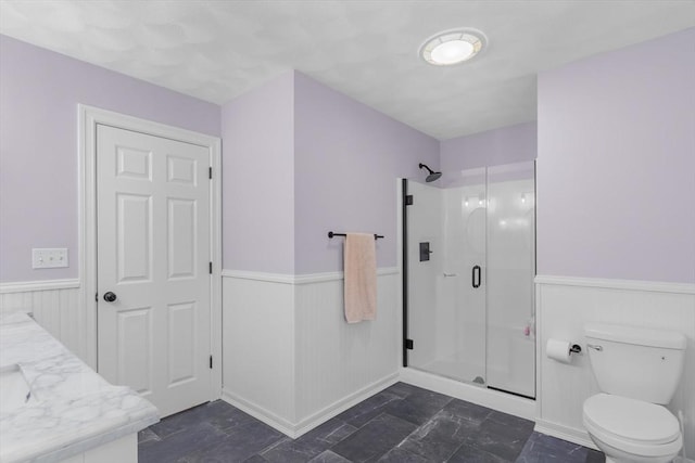 bathroom featuring vanity, toilet, and an enclosed shower