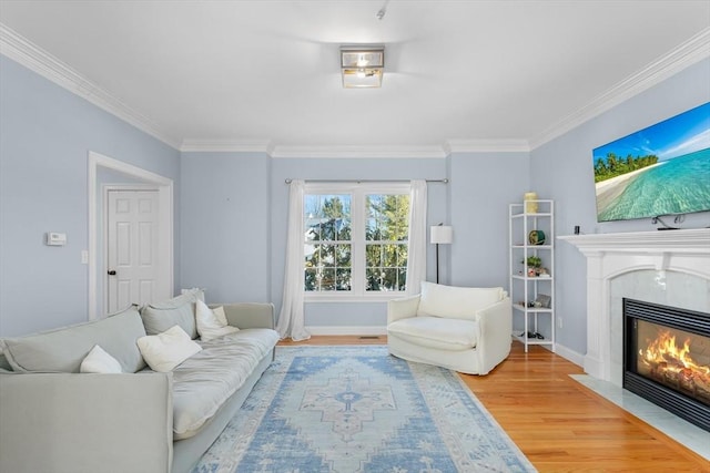 living room featuring a fireplace, hardwood / wood-style floors, and ornamental molding