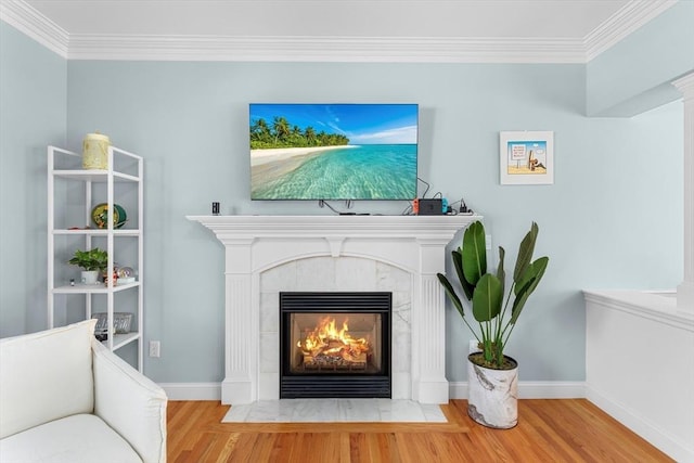 sitting room featuring hardwood / wood-style flooring, crown molding, and a tiled fireplace