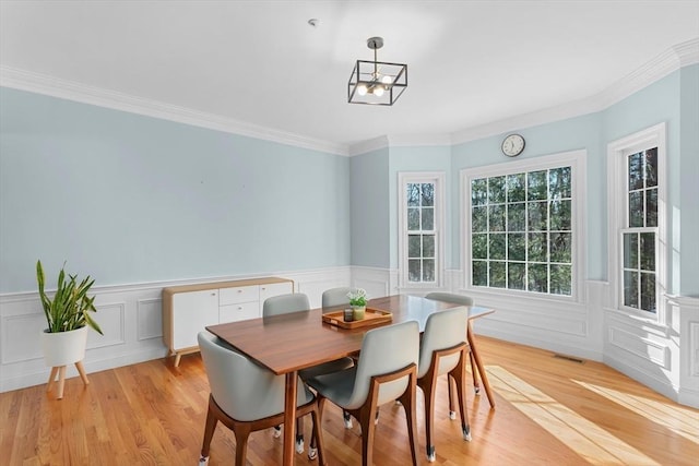 dining area featuring crown molding and light hardwood / wood-style floors