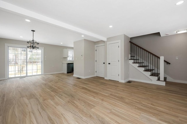 unfurnished living room featuring an inviting chandelier, beam ceiling, and light hardwood / wood-style floors