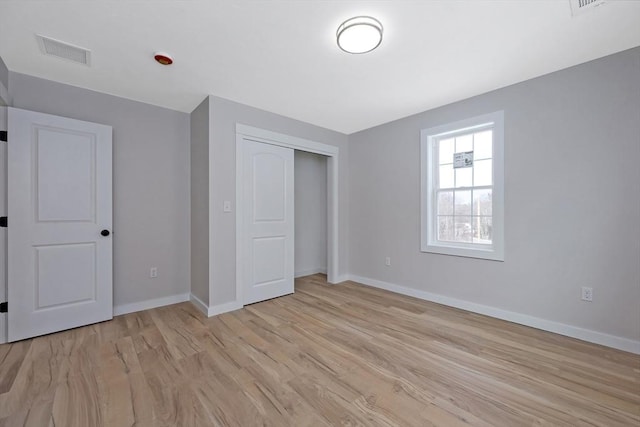 unfurnished bedroom featuring light hardwood / wood-style floors and a closet