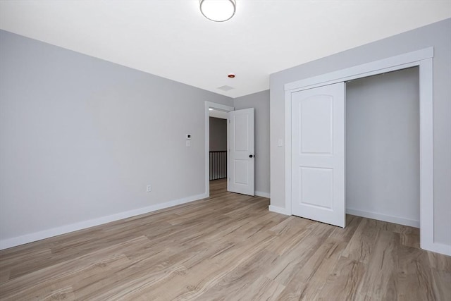 unfurnished bedroom featuring light hardwood / wood-style floors and a closet