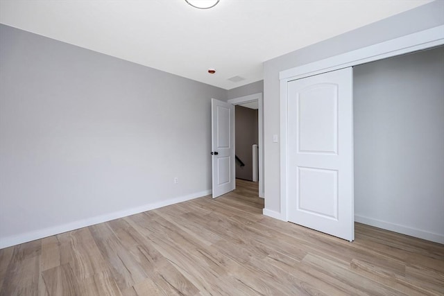 unfurnished bedroom featuring light hardwood / wood-style flooring and a closet