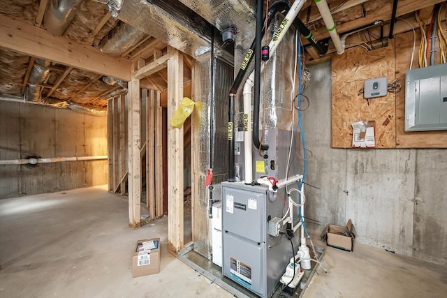 utility room featuring heating unit and electric panel