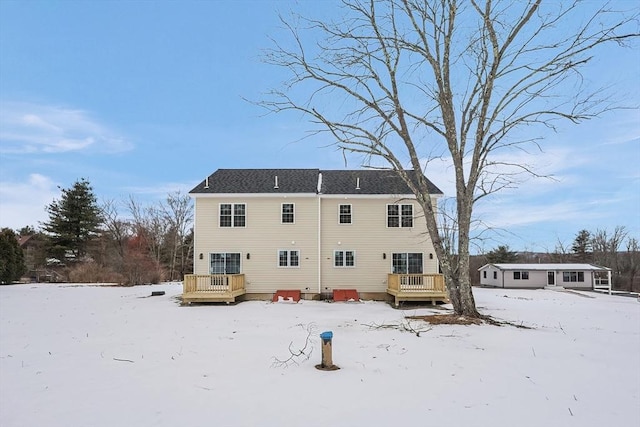 snow covered property with a wooden deck